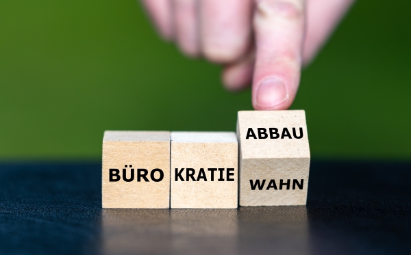 Drei Würfel mit der Aufschrift Bürokratie/Wahn/Abbau